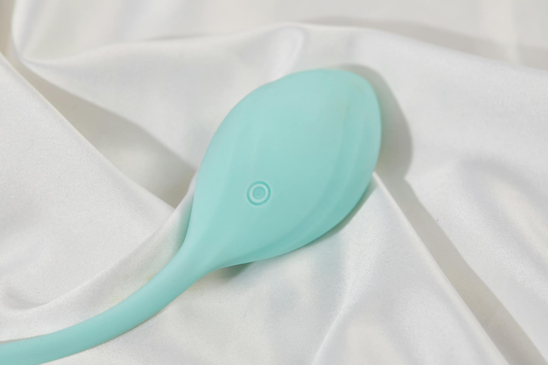 A young couple standing together indoors, holding a blue vibrator, symbolizing modern intimacy and connection.