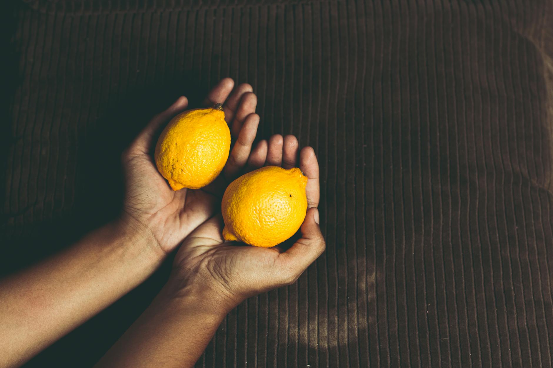 Hands holding a blue lemon vibrator together against a purple background, symbolizing shared intimacy and reconnection