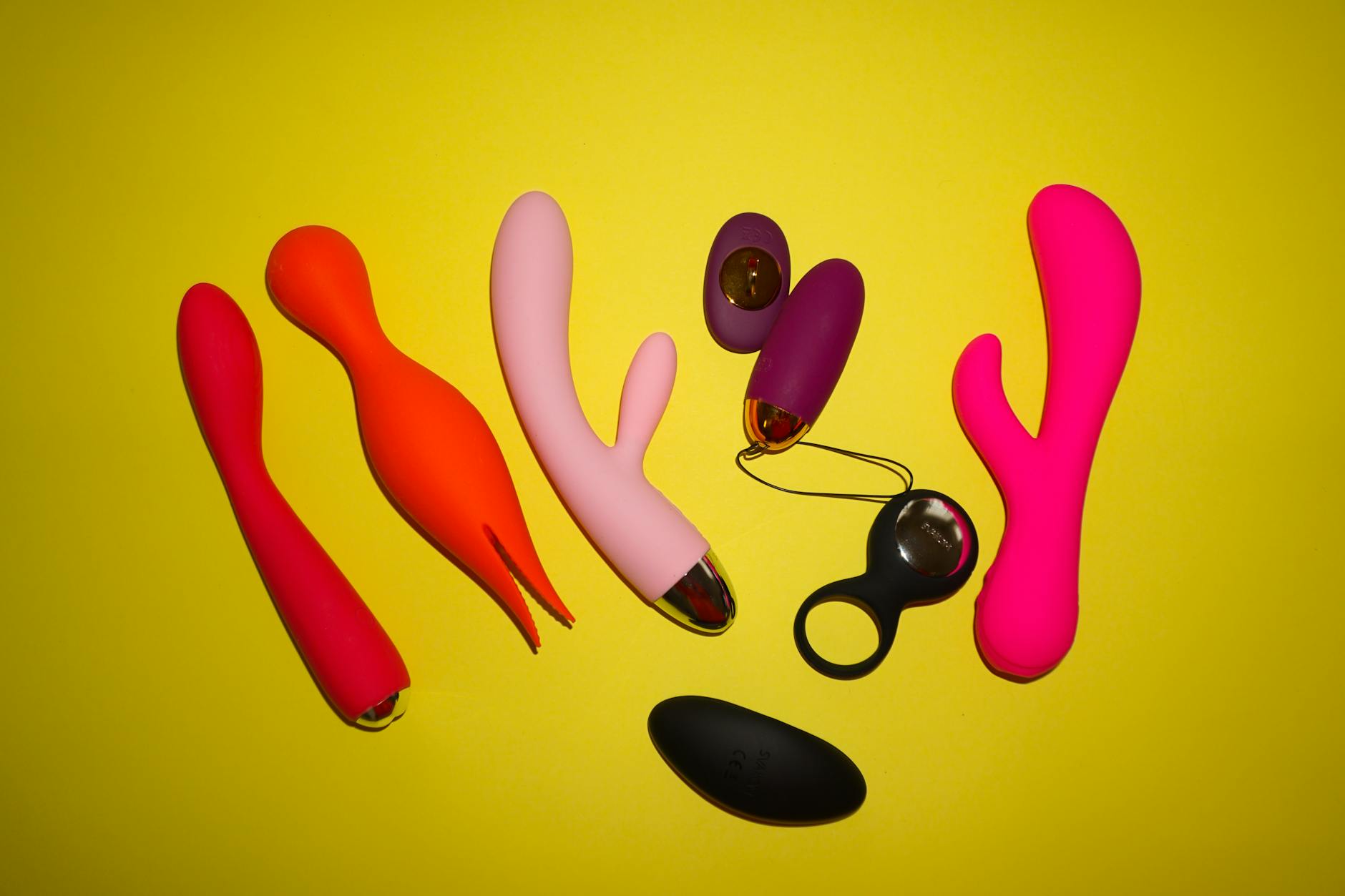 Colorful clitoral vibrators and intimate wellness toys on a bright yellow background